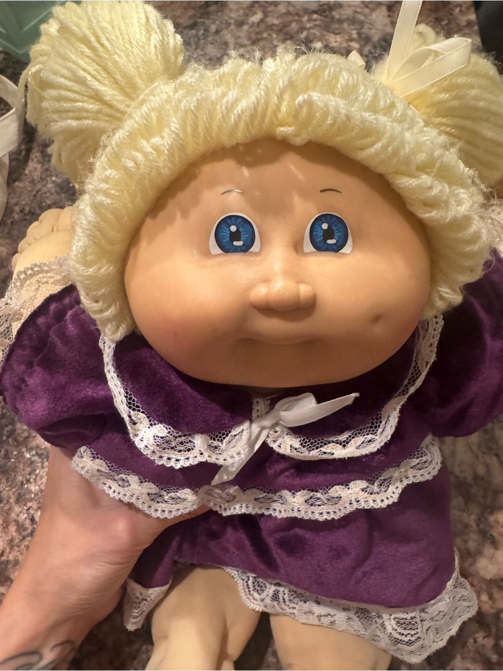 A Cabbage Patch Kid doll with blonde yarn hair and a purple dress - Picture 11 of 11